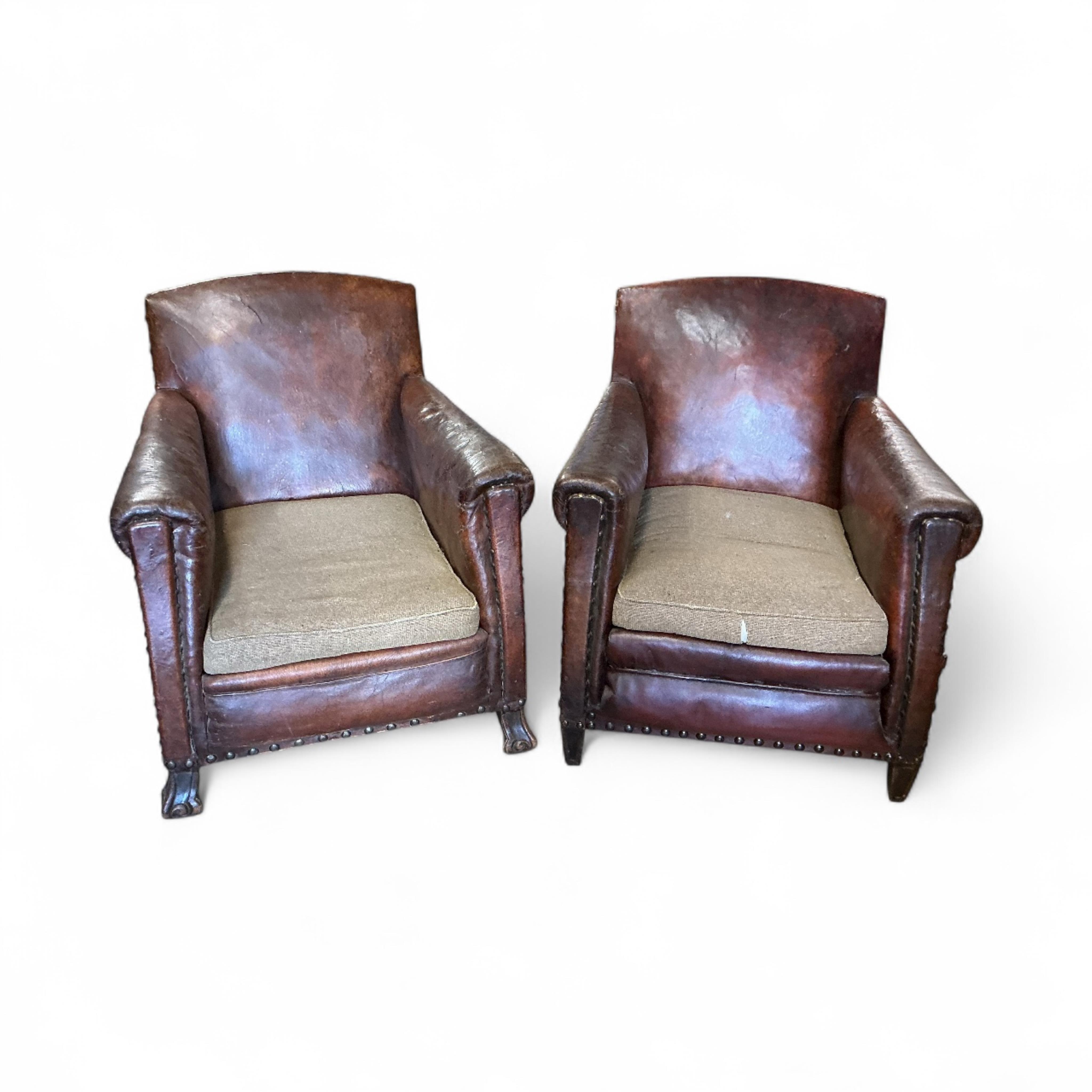 A near pair of early 20th century studded brown leather club chairs, width 79cm, depth 86cm, height 89cm